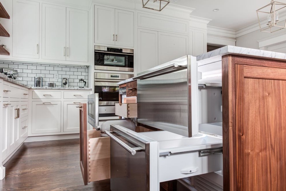 Exempel på ett mellanstort klassiskt kök, med en rustik diskho, luckor med infälld panel, vita skåp, marmorbänkskiva, vitt stänkskydd, stänkskydd i tunnelbanekakel, rostfria vitvaror, flera köksöar och brunt golv