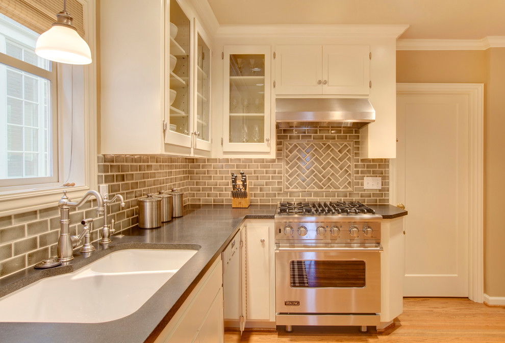 Kitchen - traditional kitchen idea in Seattle with a double-bowl sink, glass-front cabinets, beige backsplash, subway tile backsplash, stainless steel appliances and white cabinets