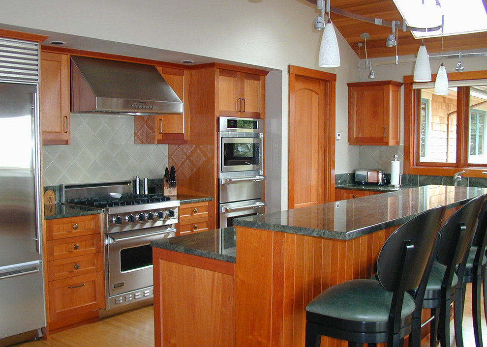 Exempel på ett stort klassiskt kök, med en undermonterad diskho, skåp i shakerstil, skåp i mellenmörkt trä, granitbänkskiva, stänkskydd i keramik, rostfria vitvaror, bambugolv, en köksö och grått stänkskydd