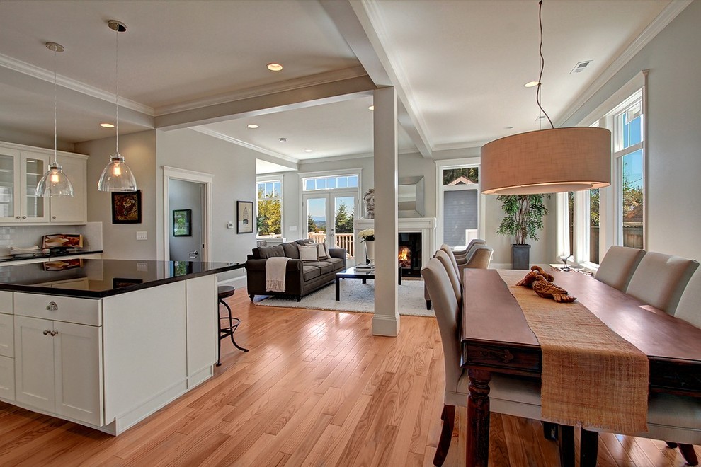 Inspiration for a mid-sized victorian l-shaped light wood floor open concept kitchen remodel in Seattle with white cabinets, white backsplash, an island, stainless steel appliances, an undermount sink, shaker cabinets, quartz countertops and subway tile backsplash