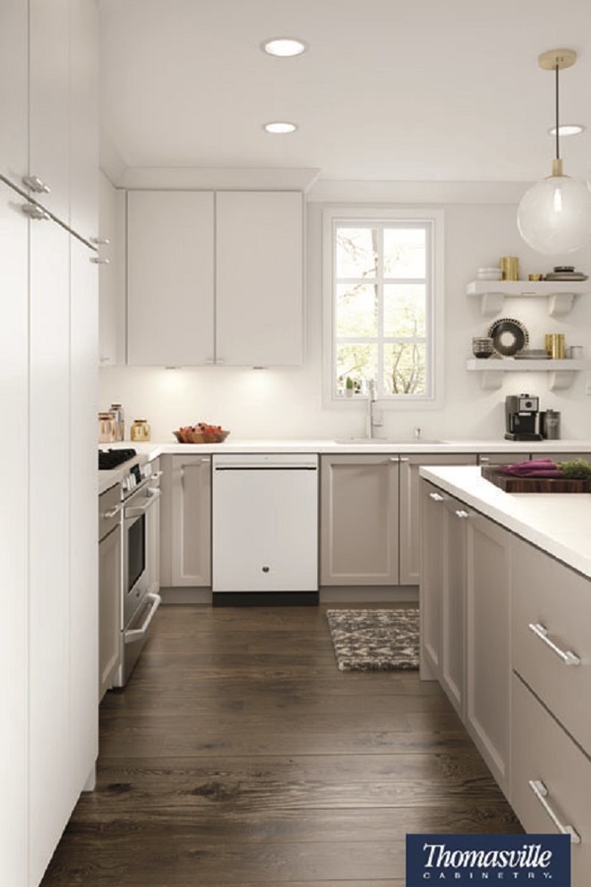 Exemple d'une petite cuisine américaine moderne en L avec un placard à porte plane, des portes de placard blanches, une crédence blanche, un électroménager en acier inoxydable, une péninsule et un sol marron.