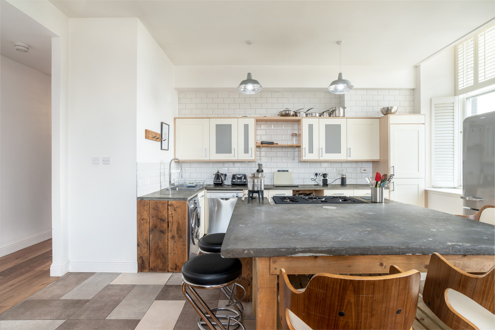 Design ideas for a large urban l-shaped open plan kitchen in Other with flat-panel cabinets, yellow cabinets, concrete worktops, white splashback, ceramic splashback, black appliances, ceramic flooring and an island.