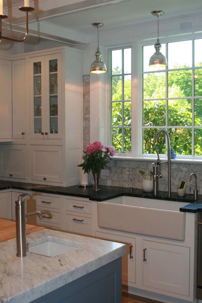 Photo of a traditional kitchen in New York with a belfast sink, beaded cabinets and white cabinets.