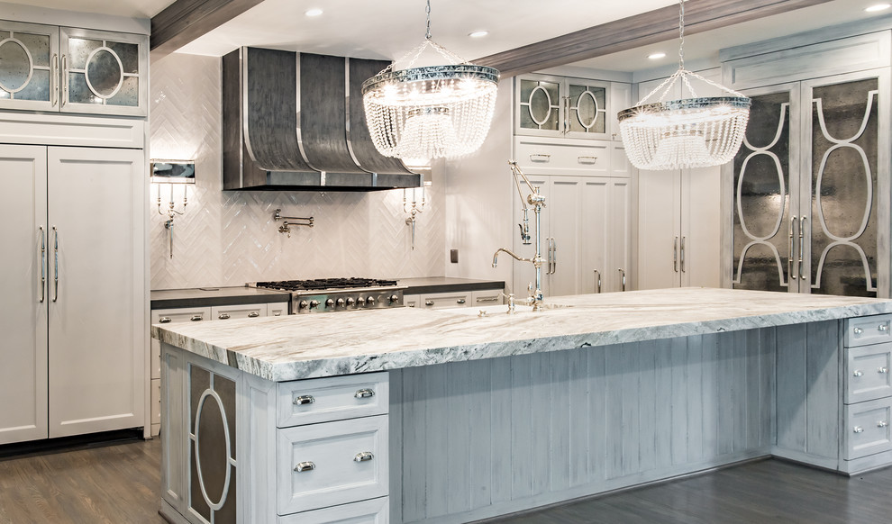 Example of a huge eclectic u-shaped light wood floor eat-in kitchen design in Houston with a farmhouse sink, glass-front cabinets, white cabinets, white backsplash, porcelain backsplash, stainless steel appliances, an island and marble countertops