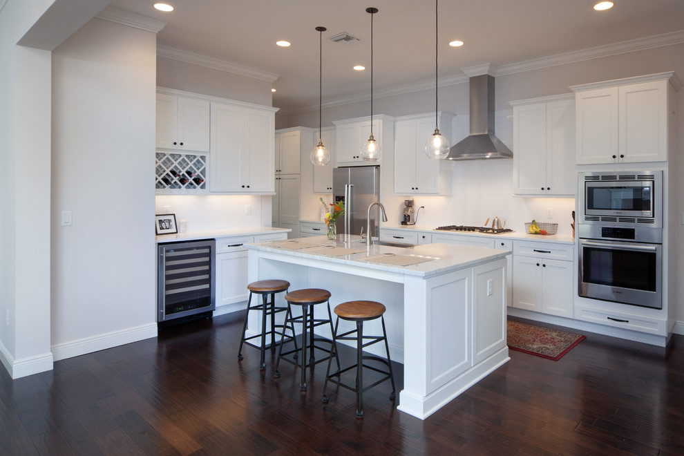 Inspiration for a large modern dark wood floor eat-in kitchen remodel in Orlando with a farmhouse sink, flat-panel cabinets, white cabinets, marble countertops, white backsplash, subway tile backsplash, stainless steel appliances and an island
