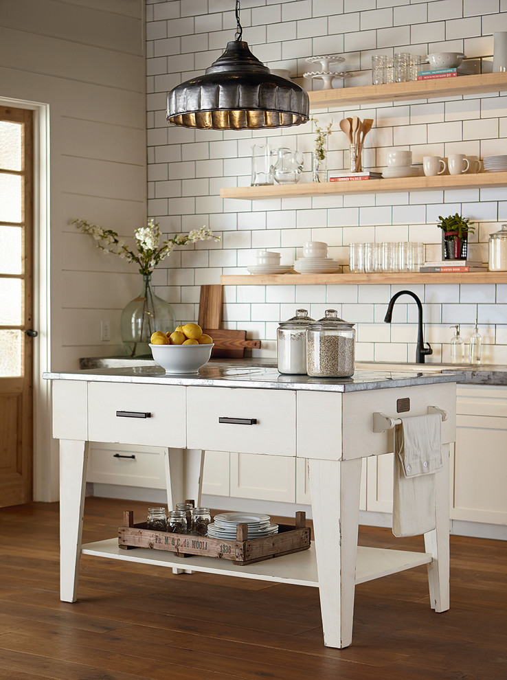 Exempel på ett lantligt kök, med en rustik diskho, släta luckor, vita skåp, bänkskiva i zink, vitt stänkskydd, stänkskydd i tunnelbanekakel, mellanmörkt trägolv och en köksö