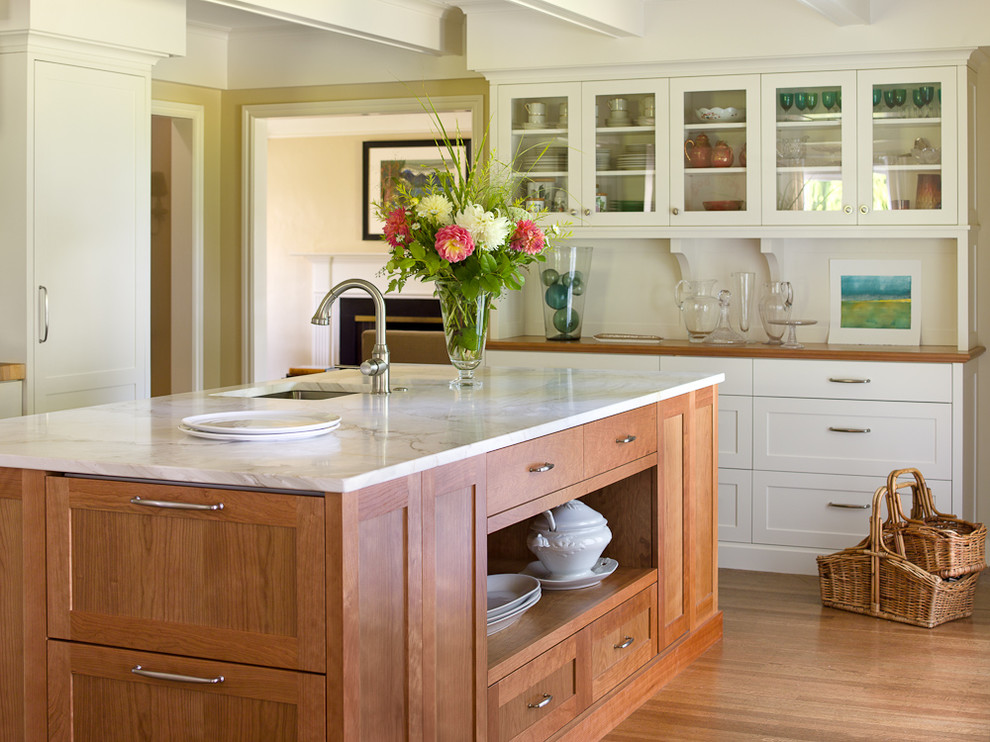 Elegant kitchen photo in Seattle with glass-front cabinets and white cabinets