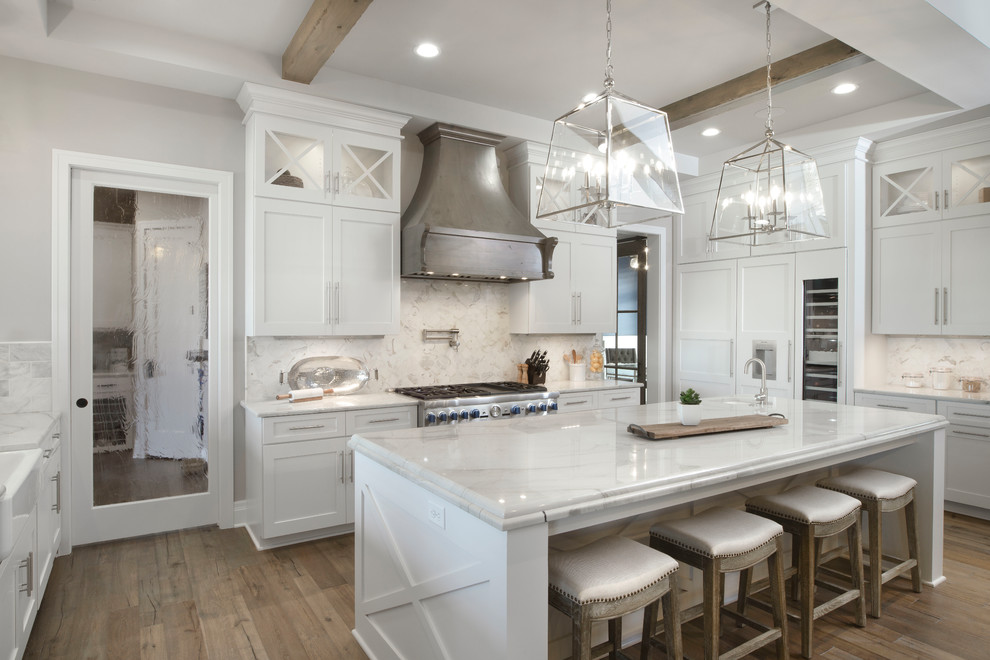 Traditional u-shaped kitchen in Wichita with a submerged sink, shaker cabinets, white cabinets, white splashback, integrated appliances, dark hardwood flooring and an island.