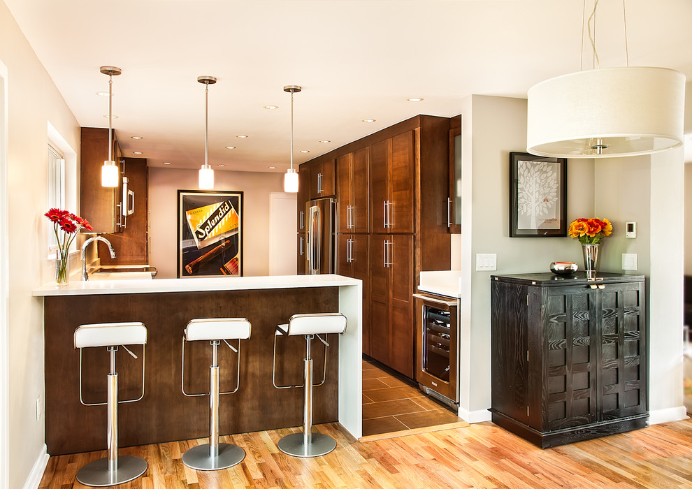 Moderne Wohnküche mit Schrankfronten mit vertiefter Füllung, dunklen Holzschränken, Quarzwerkstein-Arbeitsplatte und Küchengeräten aus Edelstahl in Seattle