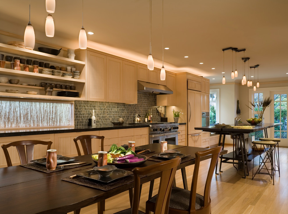 Inspiration for a mid-sized transitional galley light wood floor eat-in kitchen remodel in Seattle with an undermount sink, light wood cabinets, limestone countertops, paneled appliances and an island