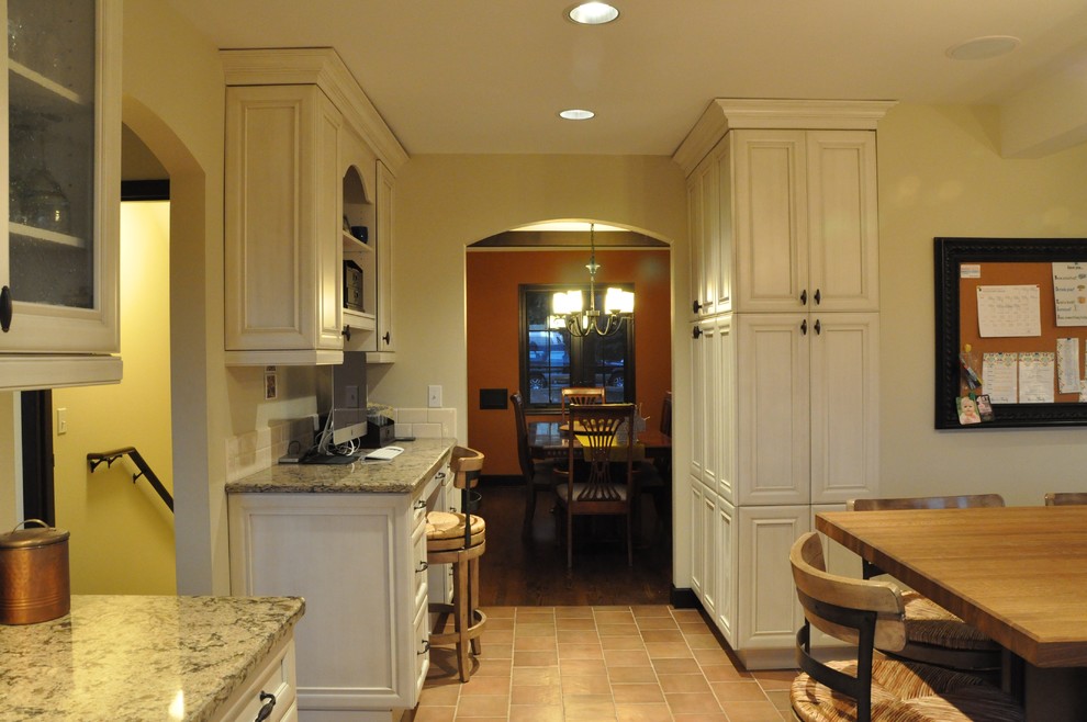 Large traditional l-shaped enclosed kitchen in Seattle with a belfast sink, recessed-panel cabinets, white cabinets, engineered stone countertops, white splashback, ceramic splashback, stainless steel appliances, porcelain flooring and an island.