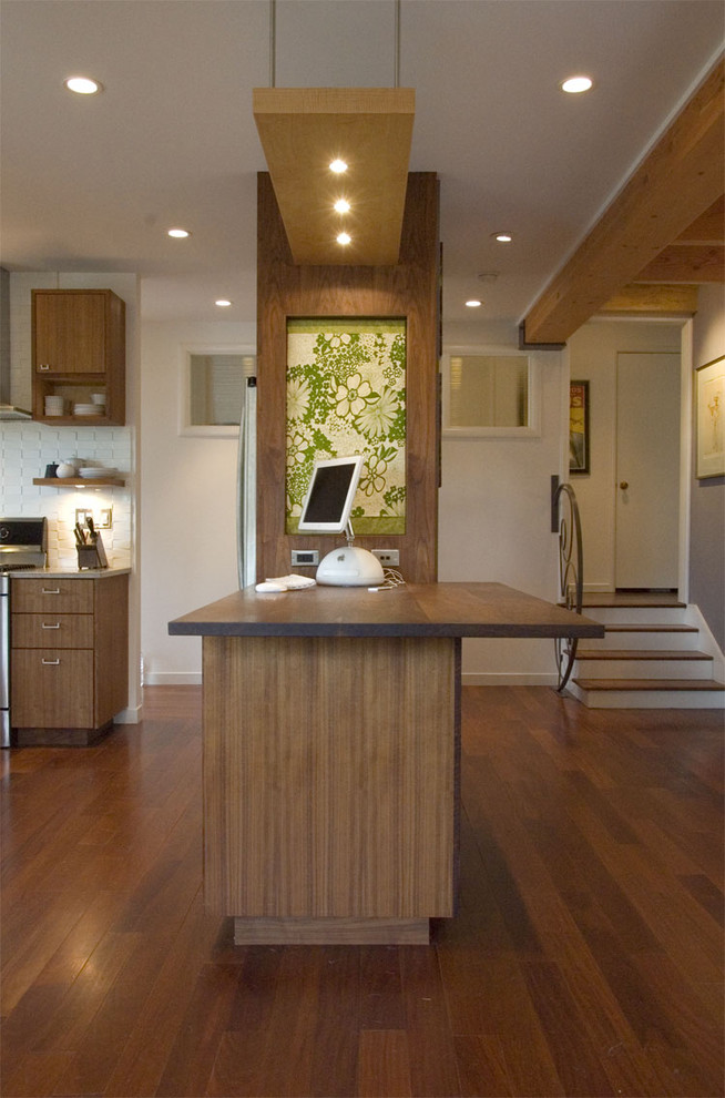 Inspiration for a mid-sized modern l-shaped medium tone wood floor open concept kitchen remodel in San Francisco with flat-panel cabinets, medium tone wood cabinets, white backsplash, ceramic backsplash, stainless steel appliances and an island