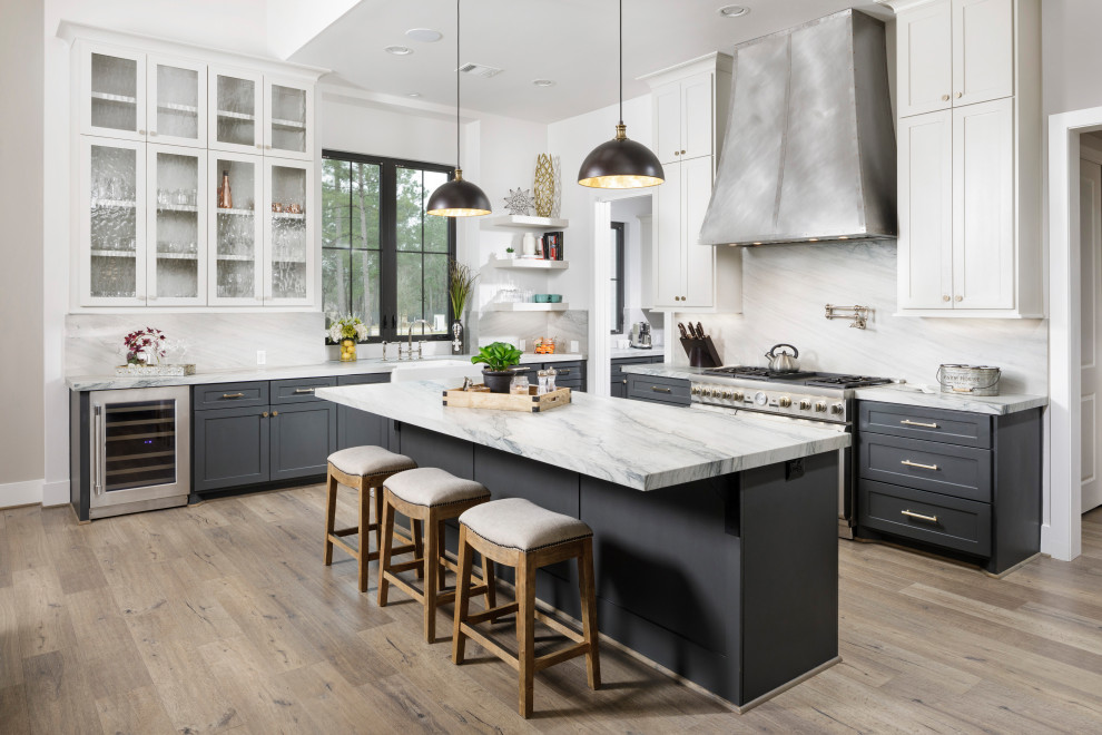 Klassisk inredning av ett stort grå grått kök, med grå skåp, vitt stänkskydd, rostfria vitvaror, laminatgolv, en köksö, grått golv, en rustik diskho, skåp i shakerstil och stänkskydd i sten