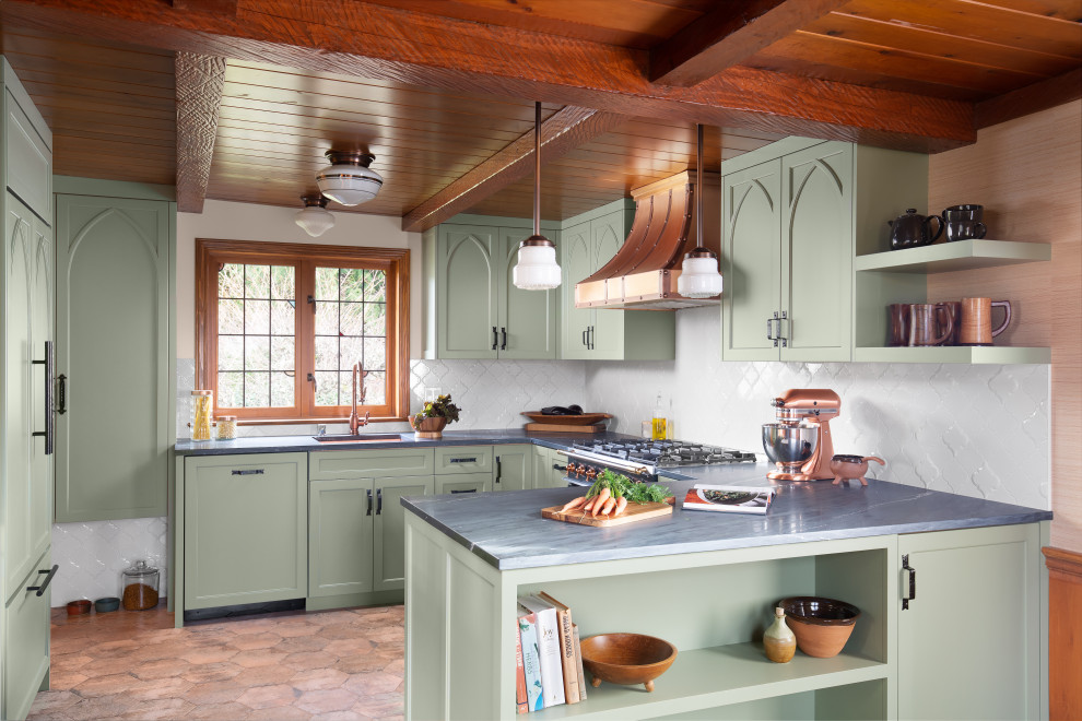 Inredning av ett mellanstort grå grått u-kök, med en undermonterad diskho, luckor med infälld panel, gröna skåp, vitt stänkskydd, en halv köksö, brunt golv, marmorbänkskiva och stänkskydd i keramik