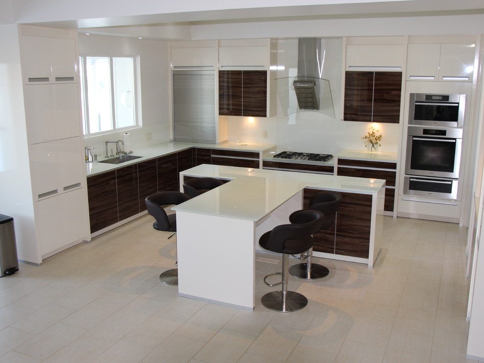 Modern u-shaped kitchen/diner in Edmonton with a submerged sink, glass-front cabinets, dark wood cabinets, glass worktops, glass sheet splashback and integrated appliances.
