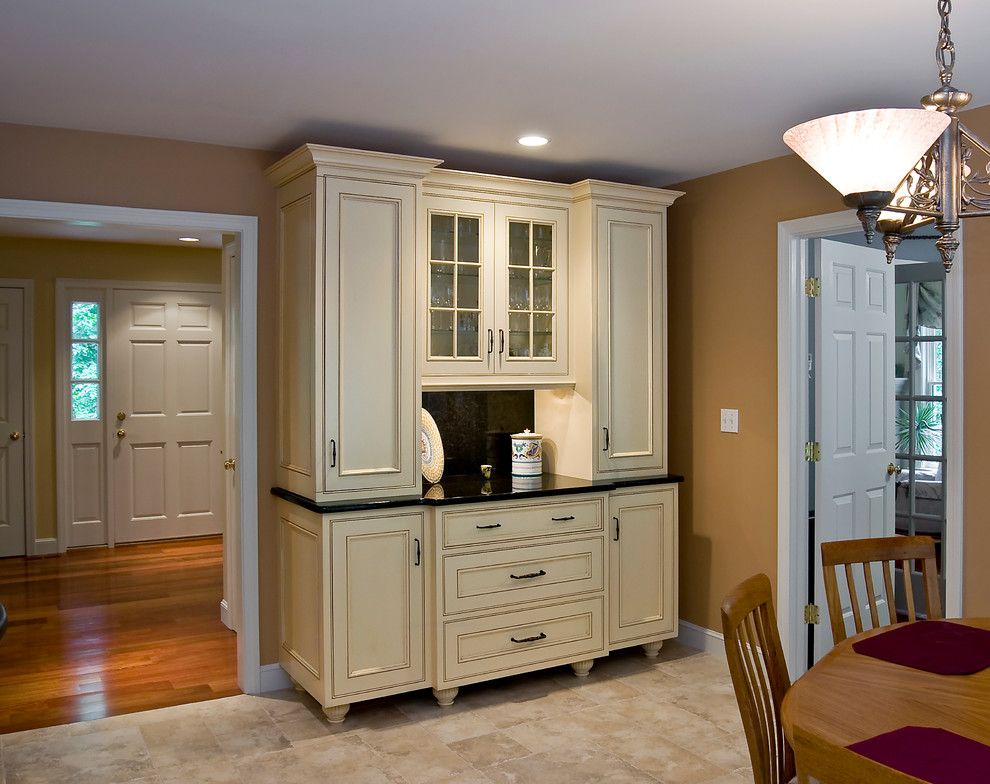 Mid-sized elegant l-shaped limestone floor and beige floor eat-in kitchen photo in Boston with an undermount sink, shaker cabinets, dark wood cabinets, solid surface countertops, stainless steel appliances and an island