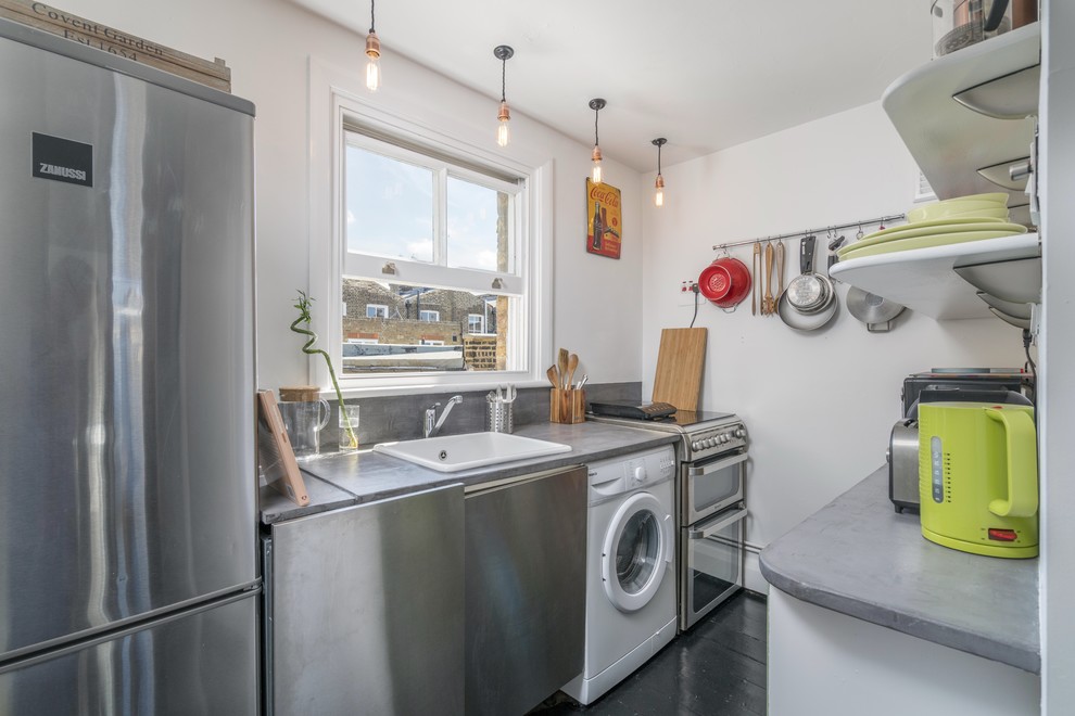 Design ideas for a small traditional galley enclosed kitchen in London with a belfast sink, flat-panel cabinets, stainless steel cabinets, concrete worktops, grey splashback, cement tile splashback, stainless steel appliances, painted wood flooring and no island.