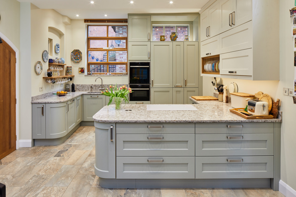 Example of a mid-sized transitional porcelain tile and multicolored floor kitchen design in Berkshire with gray cabinets, granite countertops, multicolored backsplash, multicolored countertops, an undermount sink, shaker cabinets and a peninsula