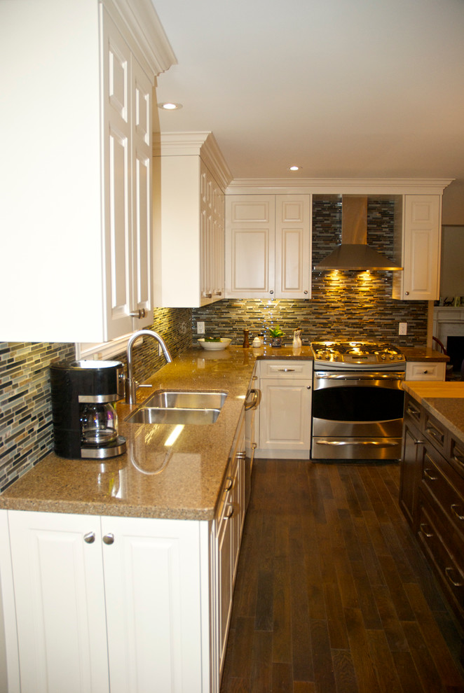 Large transitional l-shaped dark wood floor eat-in kitchen photo in Toronto with an undermount sink, raised-panel cabinets, white cabinets, quartz countertops, multicolored backsplash, glass sheet backsplash, stainless steel appliances and an island