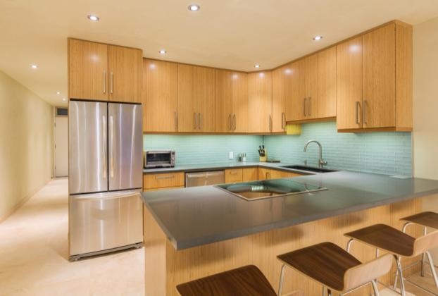 Mid-sized trendy u-shaped limestone floor kitchen photo in Calgary with an undermount sink, flat-panel cabinets, light wood cabinets, blue backsplash and glass tile backsplash