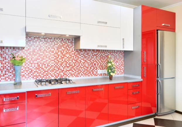 Идея дизайна: кухня в стиле фьюжн с плоскими фасадами, красными фасадами, разноцветным фартуком, фартуком из стеклянной плитки, техникой из нержавеющей стали и полом из винила