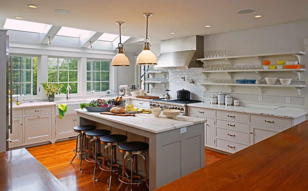 Exempel på ett mellanstort lantligt kök, med en rustik diskho, luckor med infälld panel, vita skåp, marmorbänkskiva, stänkskydd i porslinskakel, rostfria vitvaror, mellanmörkt trägolv och flera köksöar