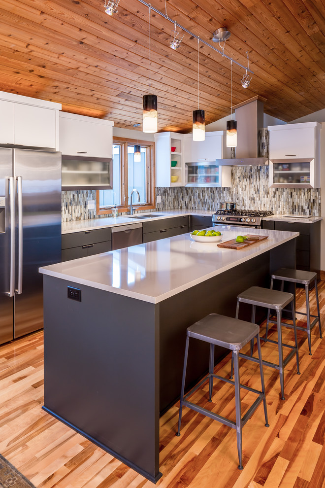 Inspiration for a contemporary l-shaped kitchen in Minneapolis with flat-panel cabinets, grey cabinets, stainless steel appliances, dark hardwood flooring and an island.
