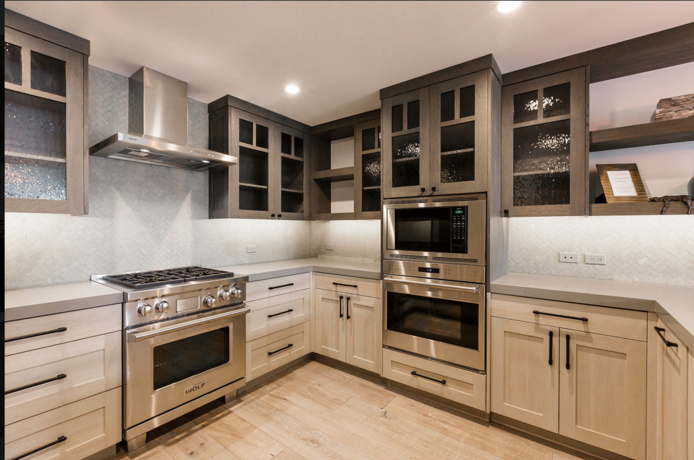 Bild på ett litet funkis kök, med skåp i shakerstil, bänkskiva i kvarts, stänkskydd i stenkakel, rostfria vitvaror, ljust trägolv och en köksö