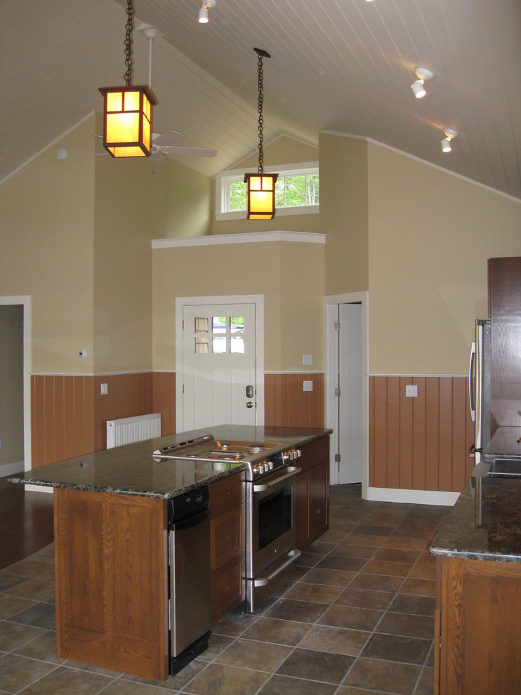Bild på ett litet amerikanskt kök, med en nedsänkt diskho, luckor med infälld panel, skåp i mellenmörkt trä, granitbänkskiva, grått stänkskydd, stänkskydd i sten, rostfria vitvaror och klinkergolv i porslin