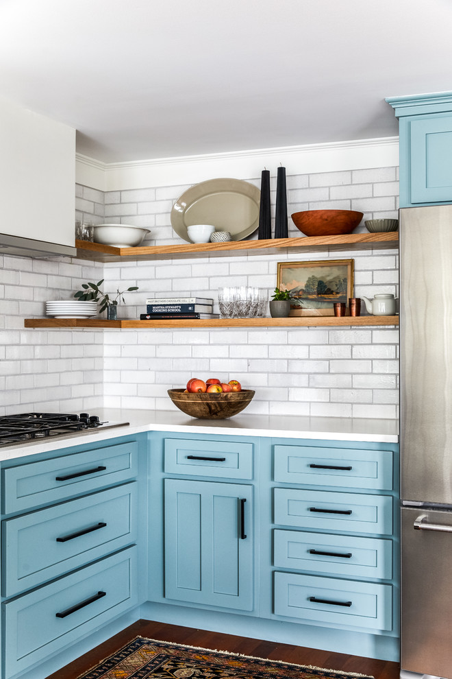 Mid-sized country u-shaped medium tone wood floor and red floor eat-in kitchen photo in Portland Maine with shaker cabinets, blue cabinets, white backsplash, brick backsplash, stainless steel appliances, no island and white countertops
