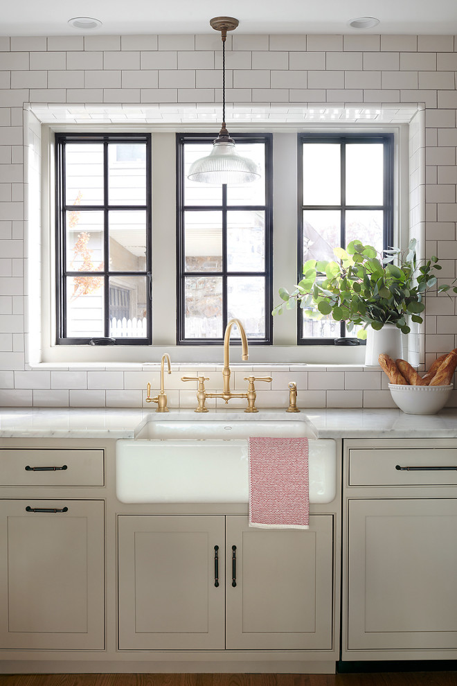 Inspiration för ett mellanstort vintage vit vitt kök, med en rustik diskho, luckor med profilerade fronter, beige skåp, marmorbänkskiva, vitt stänkskydd, stänkskydd i tunnelbanekakel, integrerade vitvaror, mellanmörkt trägolv, en halv köksö och orange golv