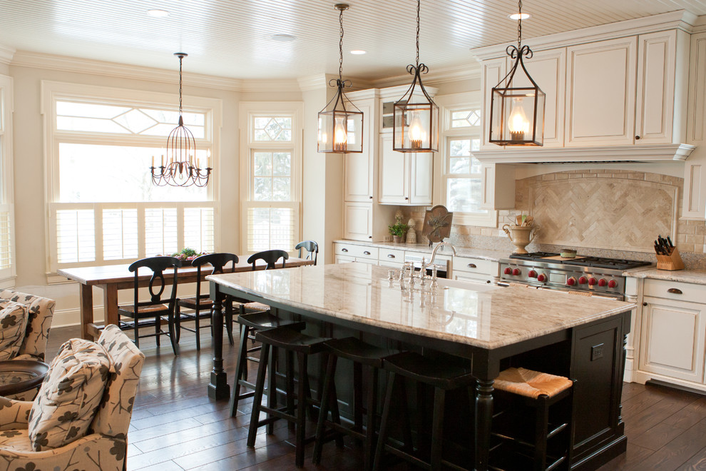 Eat-in kitchen - large transitional l-shaped dark wood floor eat-in kitchen idea in Chicago with raised-panel cabinets, white cabinets, granite countertops, beige backsplash, stainless steel appliances, an island, a farmhouse sink and porcelain backsplash