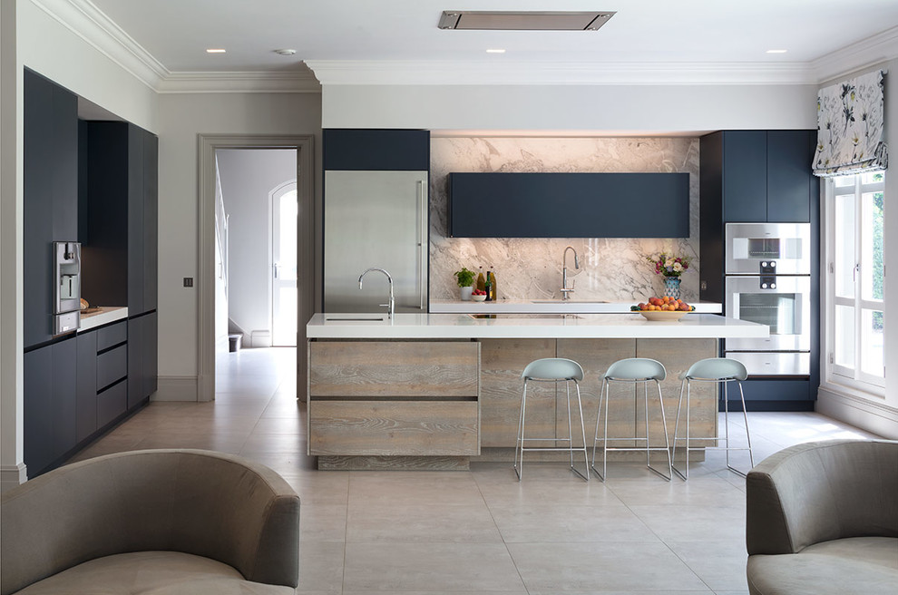 Inspiration for a large contemporary l-shaped open plan kitchen in London with flat-panel cabinets, blue cabinets, composite countertops, beige splashback, marble splashback, stainless steel appliances, an island and white worktops.