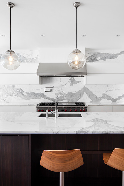 Idee per un grande cucina con isola centrale design con top in marmo, paraspruzzi bianco, paraspruzzi in marmo e elettrodomestici in acciaio inossidabile