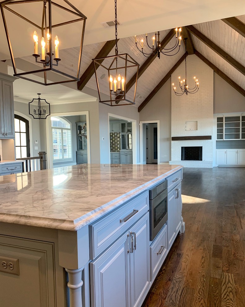 Country dark wood floor open concept kitchen photo in Atlanta with a farmhouse sink, beaded inset cabinets, gray cabinets, marble countertops, stainless steel appliances, an island and white countertops
