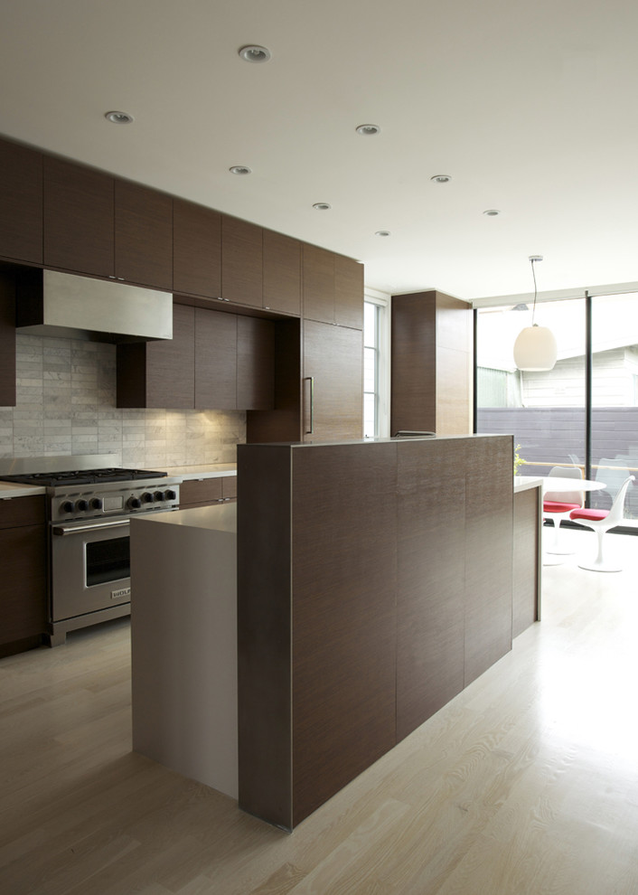 Foto di una cucina minimalista con ante lisce, ante in legno bruno e paraspruzzi grigio