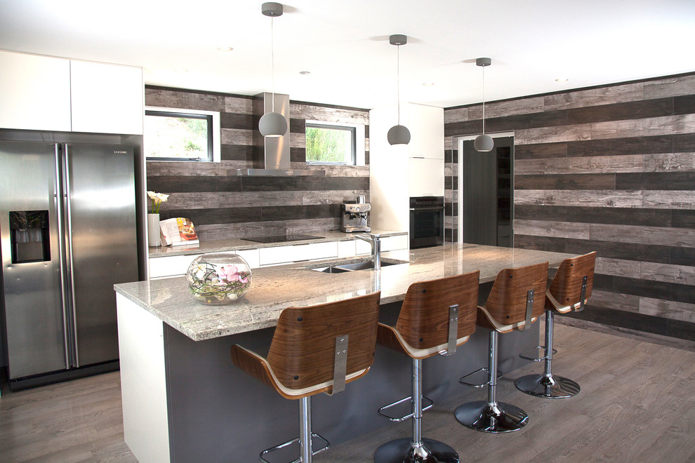 Immagine di una cucina contemporanea di medie dimensioni con lavello a doppia vasca, top in granito, paraspruzzi con piastrelle in ceramica, elettrodomestici in acciaio inossidabile, pavimento in laminato e top beige