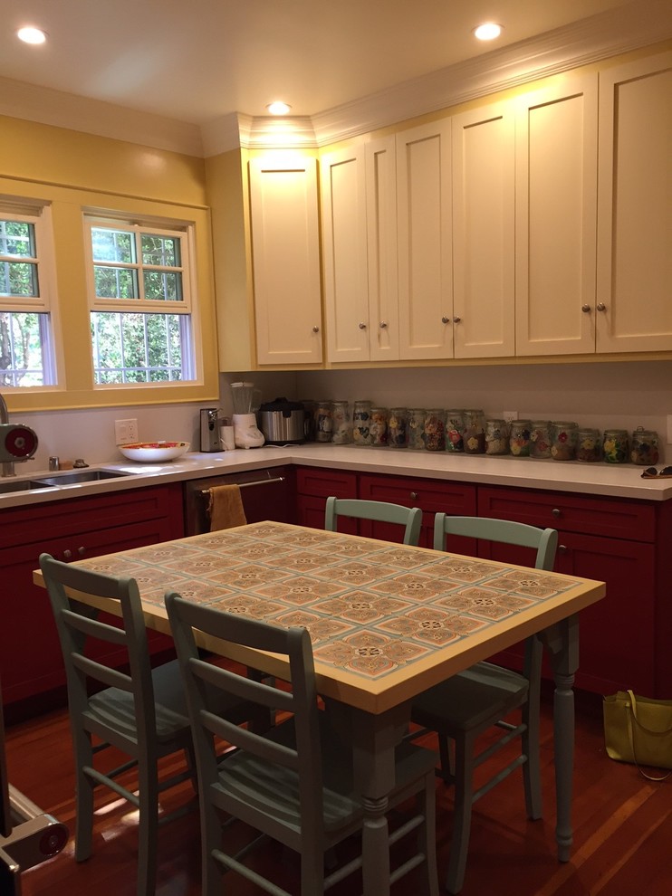 Foto di una grande cucina stile americano con ante rosse, paraspruzzi beige, elettrodomestici in acciaio inossidabile, lavello a doppia vasca, ante con riquadro incassato, top in superficie solida e parquet scuro