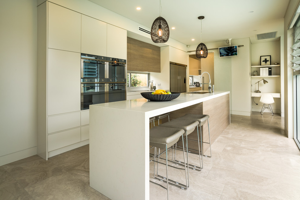 シドニーにあるコンテンポラリースタイルのおしゃれなキッチン (フラットパネル扉のキャビネット、白いキャビネット、シルバーの調理設備) の写真