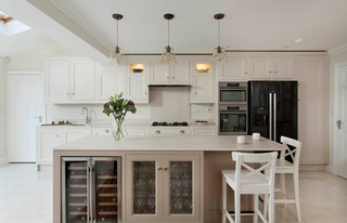 A luxurious cream colored kitchen with black granite counter tops,  stainless steel KitchenAid appliances and Edison bulbs above the island  Stock Photo - Alamy