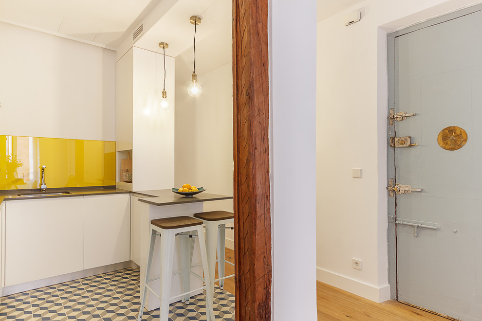 Immagine di una piccola cucina minimal con pavimento in legno massello medio