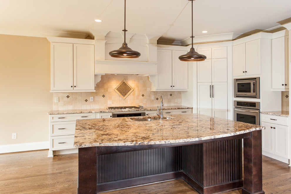 Example of a classic l-shaped eat-in kitchen design in Other with a double-bowl sink, granite countertops, multicolored backsplash, stone tile backsplash, stainless steel appliances and an island