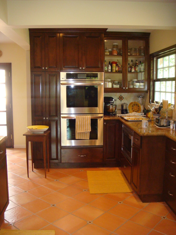 Example of a small classic l-shaped terra-cotta tile enclosed kitchen design in San Francisco with recessed-panel cabinets, dark wood cabinets, marble countertops, beige backsplash, mosaic tile backsplash and stainless steel appliances