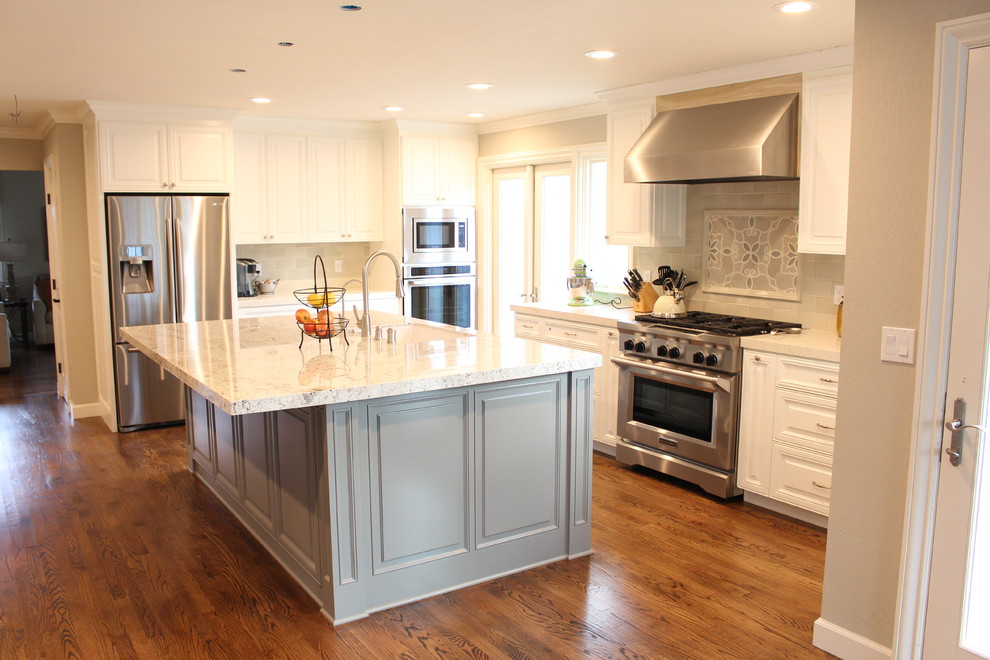 Exempel på ett mellanstort klassiskt kök, med en undermonterad diskho, luckor med upphöjd panel, vita skåp, granitbänkskiva, grått stänkskydd, stänkskydd i mosaik, rostfria vitvaror, mellanmörkt trägolv och en köksö