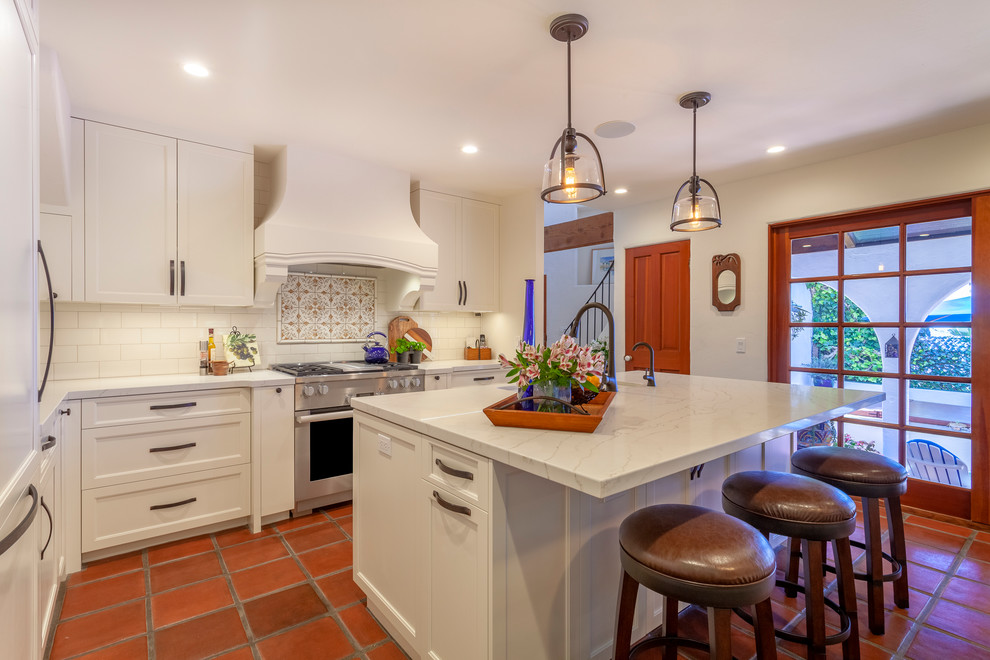 Idéer för att renovera ett mellanstort medelhavsstil vit vitt l-kök, med vita skåp, rostfria vitvaror, en köksö, skåp i shakerstil, flerfärgad stänkskydd, klinkergolv i terrakotta och orange golv