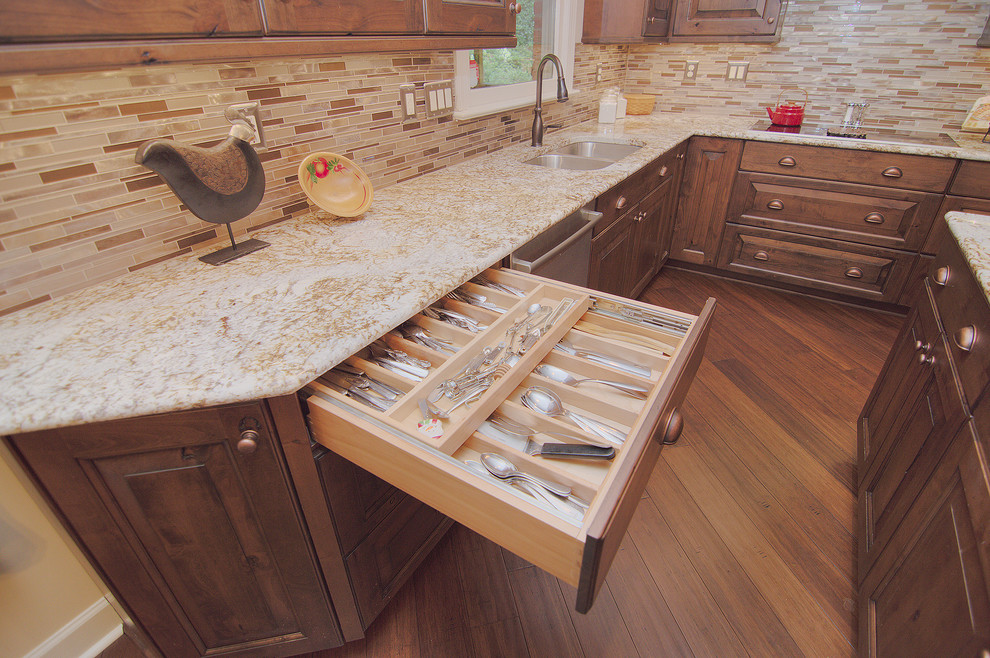 Exempel på ett mellanstort rustikt kök, med en undermonterad diskho, luckor med upphöjd panel, skåp i mellenmörkt trä, granitbänkskiva, beige stänkskydd, stänkskydd i stickkakel, rostfria vitvaror, mellanmörkt trägolv, flera köksöar och brunt golv