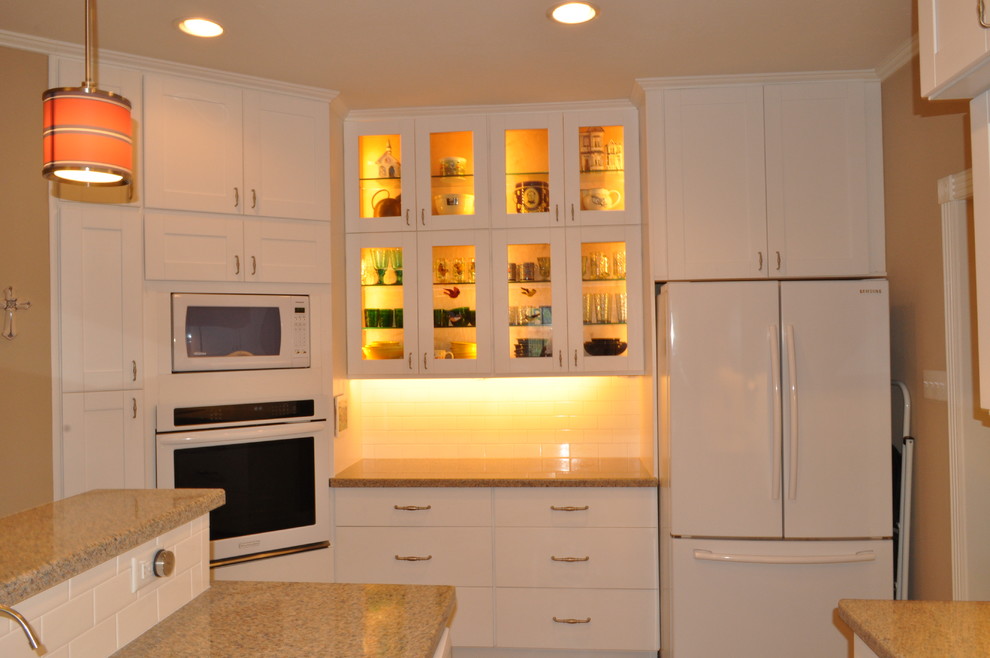 Immagine di una cucina minimalista di medie dimensioni con lavello sottopiano, ante con riquadro incassato, ante bianche e elettrodomestici bianchi