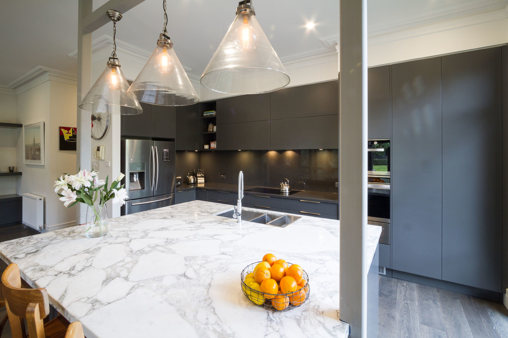 Immagine di una cucina contemporanea di medie dimensioni con lavello sottopiano, ante lisce, ante grigie, top in marmo, parquet scuro e paraspruzzi in lastra di pietra