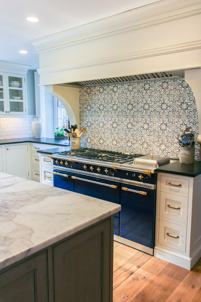 Exempel på ett stort lantligt kök, med en rustik diskho, luckor med profilerade fronter, vita skåp, marmorbänkskiva, flerfärgad stänkskydd, stänkskydd i cementkakel, integrerade vitvaror, ljust trägolv och en köksö