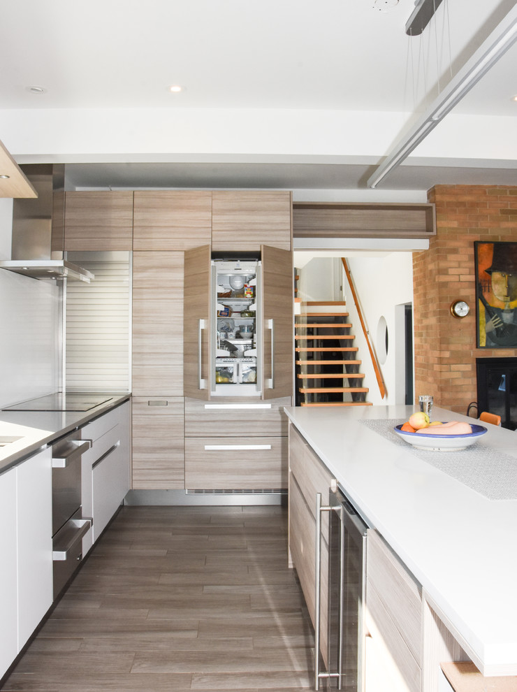 Immagine di una cucina minimalista di medie dimensioni con lavello sottopiano, ante lisce, ante bianche, top in superficie solida, elettrodomestici bianchi e parquet chiaro